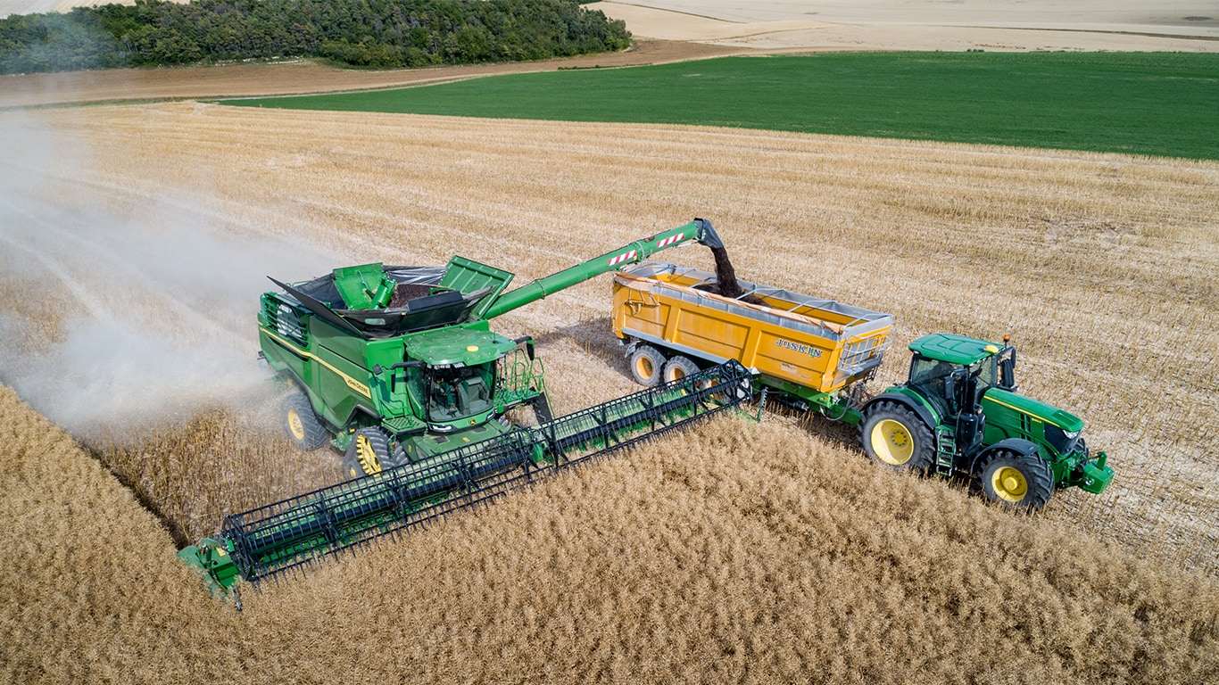 קומביין מסדרת John Deere X פורק זרעי לפתית לעגלת גרעינים הנגררת ע&quot;י טרקטור John Deere