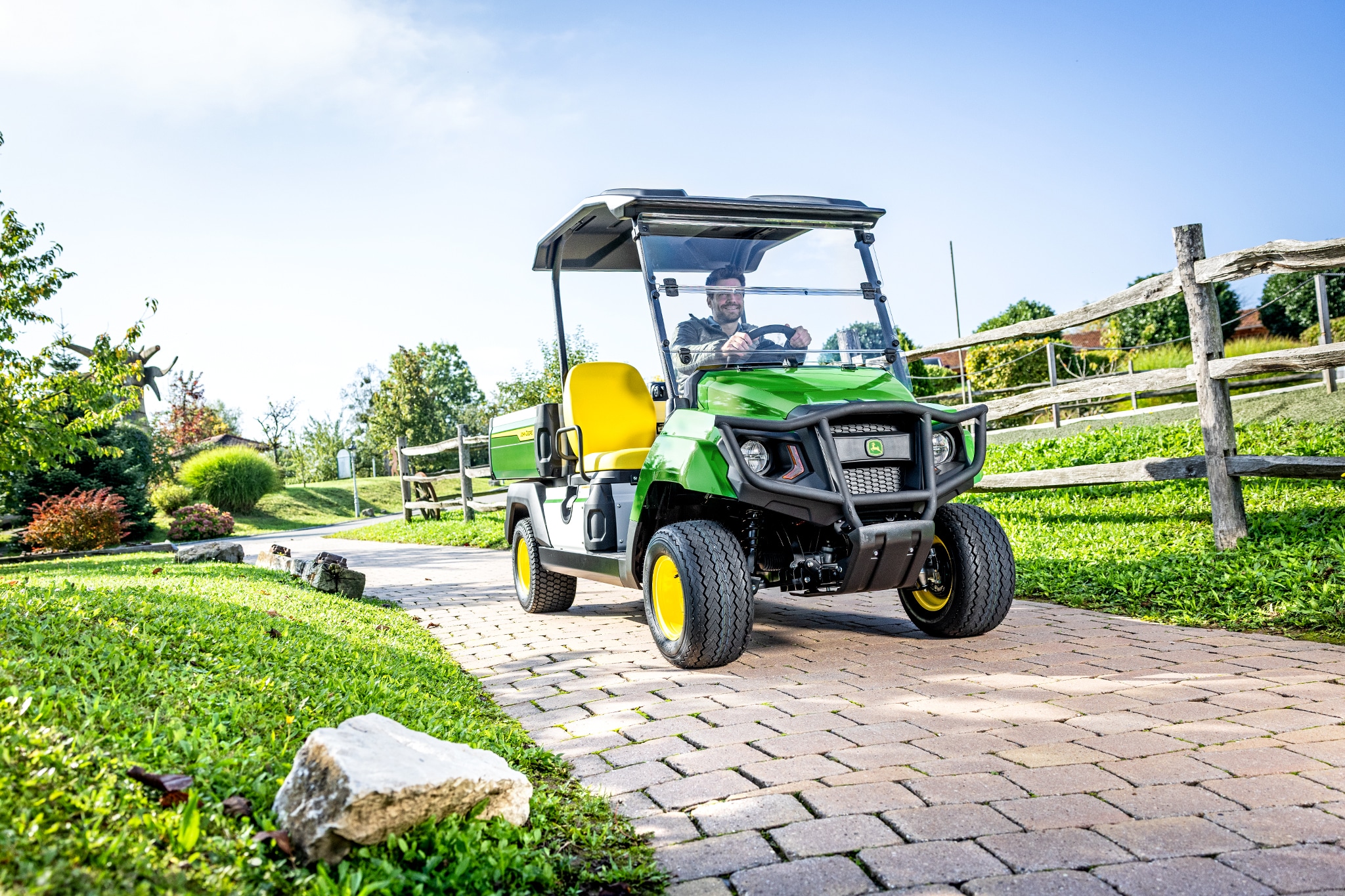 רכב ייעודי Gator GS נוסע בכביש נתיב סלול באזור גינון רכב ייעודי Gator GS נוסע בכביש נתיב סלול באזור גינון