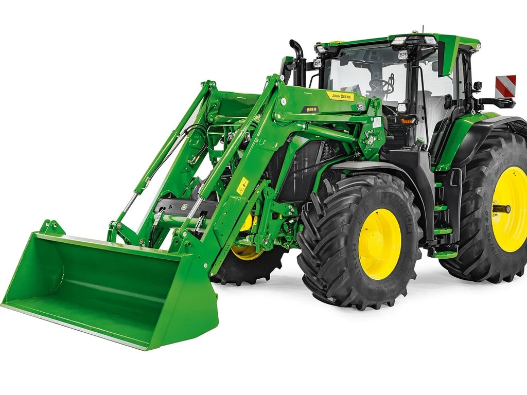 טרקטור John Deere עם מעמיס קדמי פתוח וכף, תמונת סטודיו המדגישה את טווח המעמיס ואת גובה ההרמה.